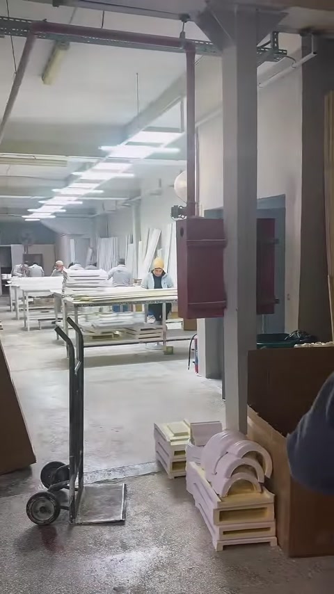 Production tables and finished decorative components are displayed in the spacious workshop.