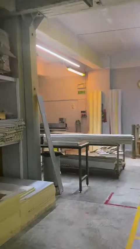 Workbenches and tables are visible in the transition area of the production section.