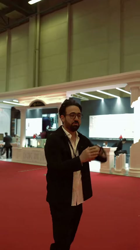 Il presentatore spiega la composizione dell'ingresso fieristico realizzata con colonne decorative.