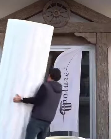 Un fusto di colonna scanalato viene trasportato verticalmente verso l'area di posa