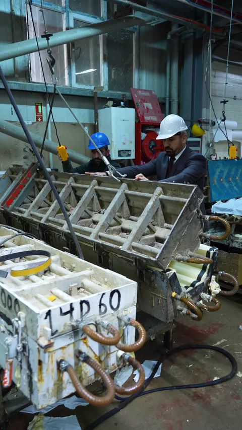 Workers carrying out a production stage on a metal mold setup