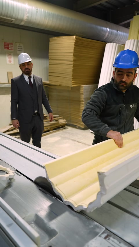 Yellow and white crown molding profiles are compared on a workbench