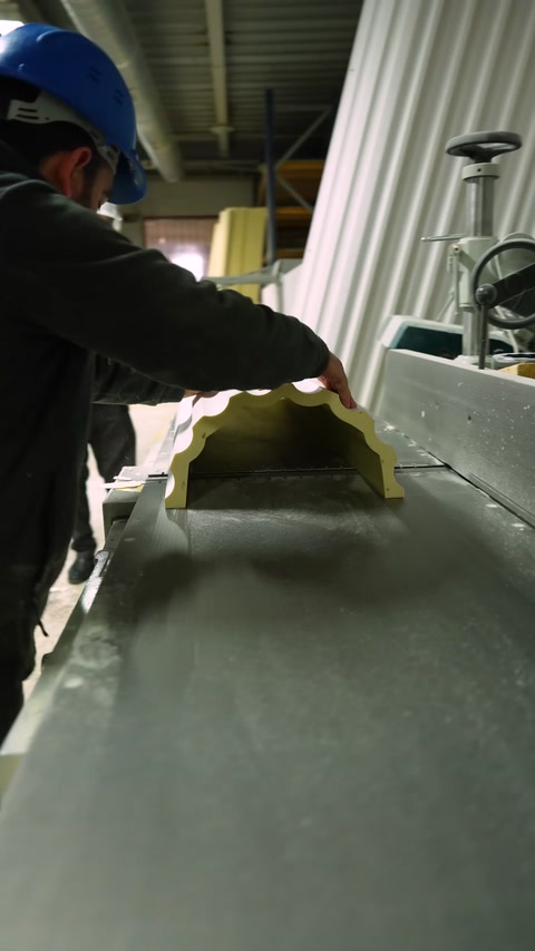 A yellow decorative profile is cut on a circular saw bench