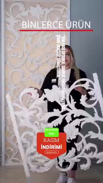 A wide decorative panel sample with botanical motifs is presented by hand