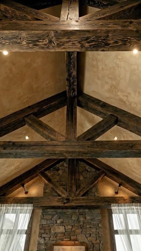 Intersecting rafters and beams form a decorative pitched ceiling structure