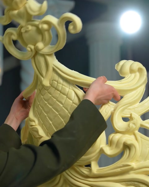 Operaio che assembla manualmente le sezioni dell'ornamento a voluta