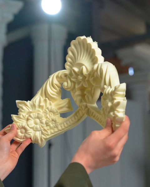 Pezzo di ornamento a voluta floreale con motivo a conchiglia tenuto