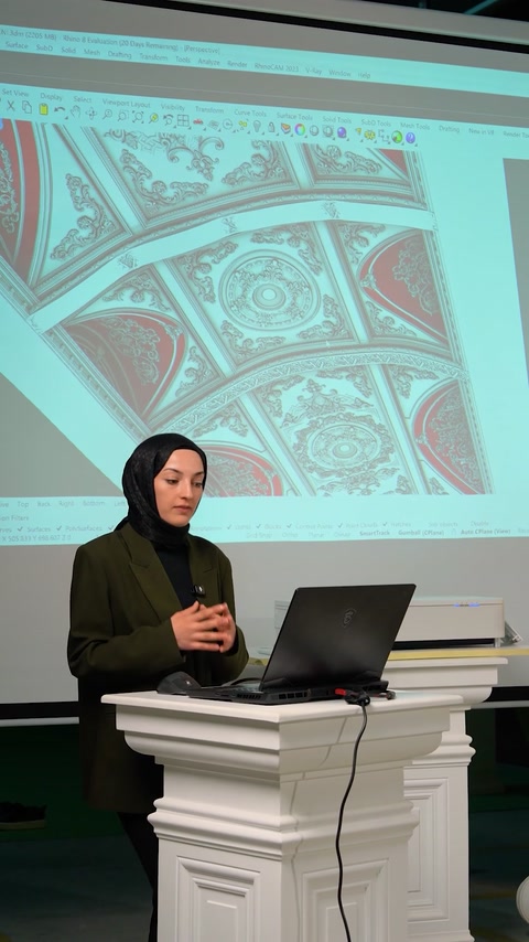 Presenter explains flexible cornice production process at podium