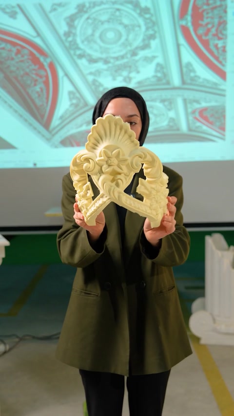 Hand holding carved flexible ceiling medallion fragment sample