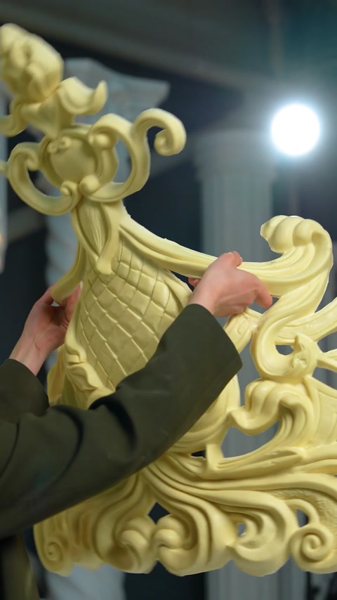 Worker assembling scroll ornament sections by hand