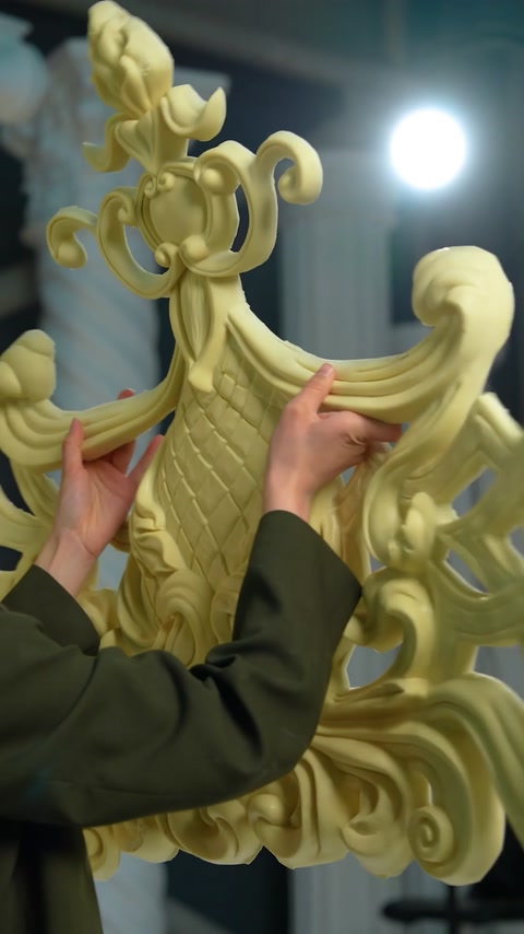 Hands fitting curved cornice sections together during assembly