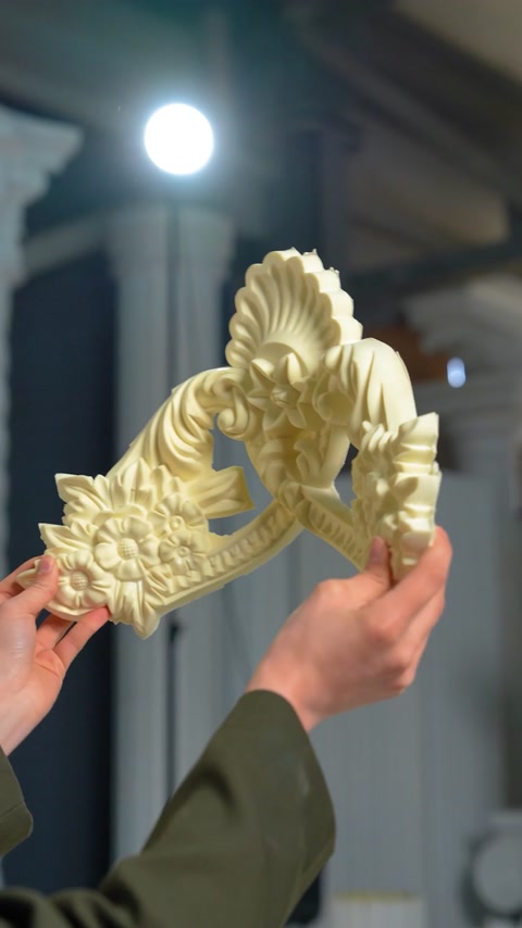 Floral scroll ornament piece with shell motif held up