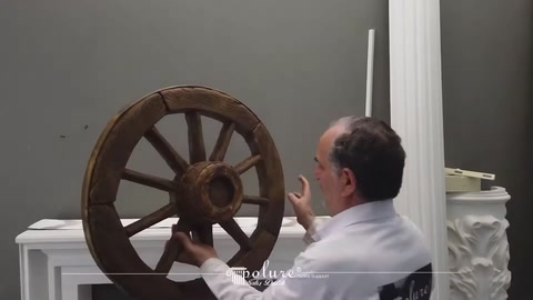 Dekoratif ahşap görünümlü at arabası tekeri sergileniyor