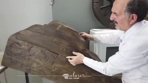Un ampio pezzo di tronco con effetto legno esposto con entrambe le mani