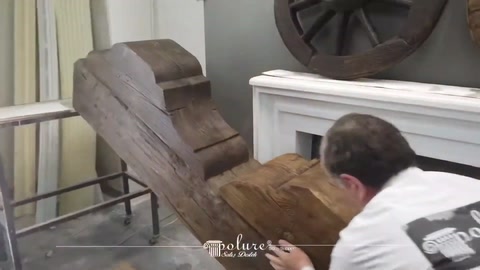 Il presentatore esamina la disposizione dei pezzi decorativi a forma di tronco sul pavimento