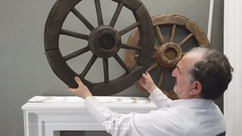 Dark wheel model presented front-facing in the server's hands