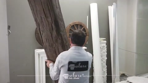 Server gripping a long rustic beam model in vertical position