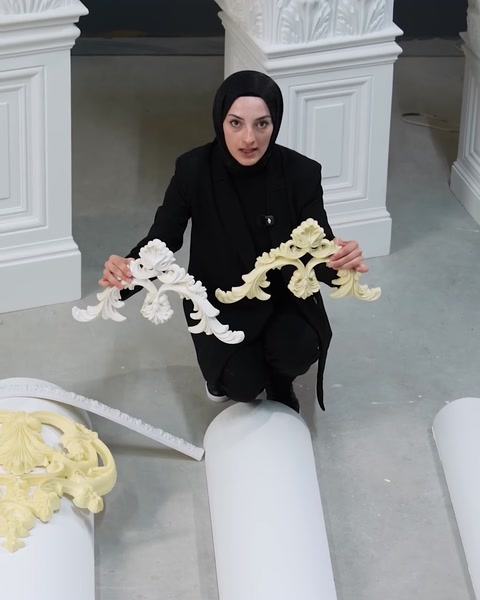 Donna che tiene una modanatura ornamentale flessibile bianca sopra una superficie curva