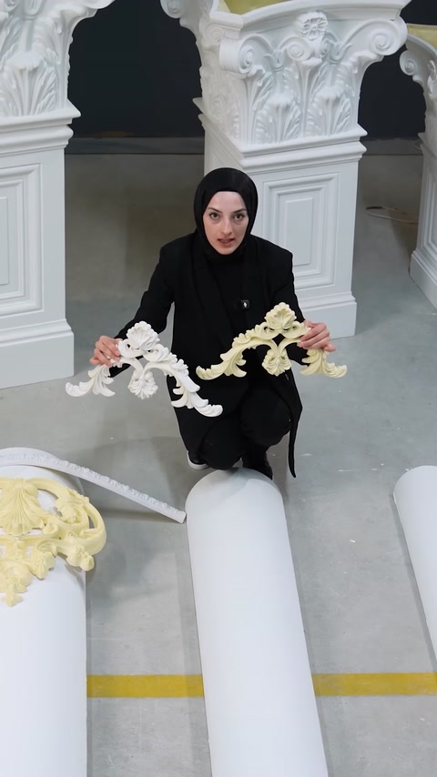 Donna che tiene una modanatura ornamentale flessibile bianca sopra una superficie curva