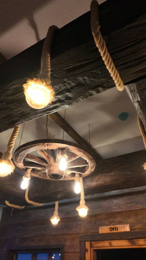 Si vede il dettaglio della ruota e della lampadina sospesa collegata alla trave decorativa