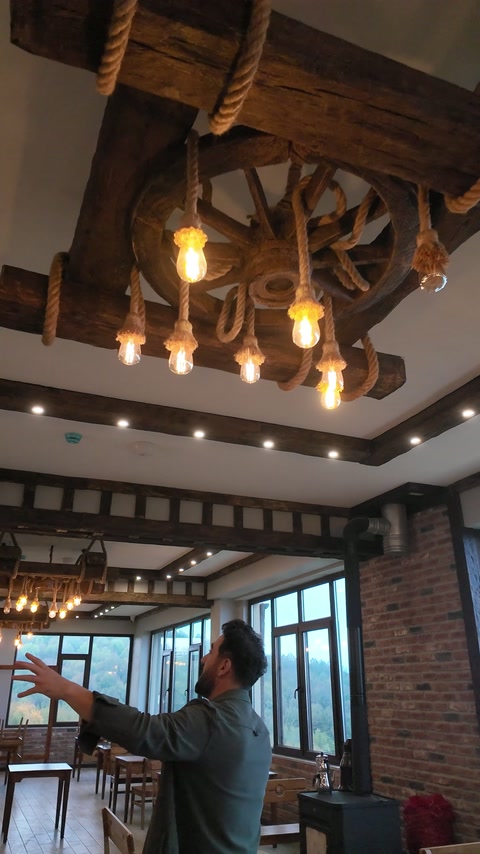 Tra le travi scure del soffitto si vede una composizione di luci decorative sospese
