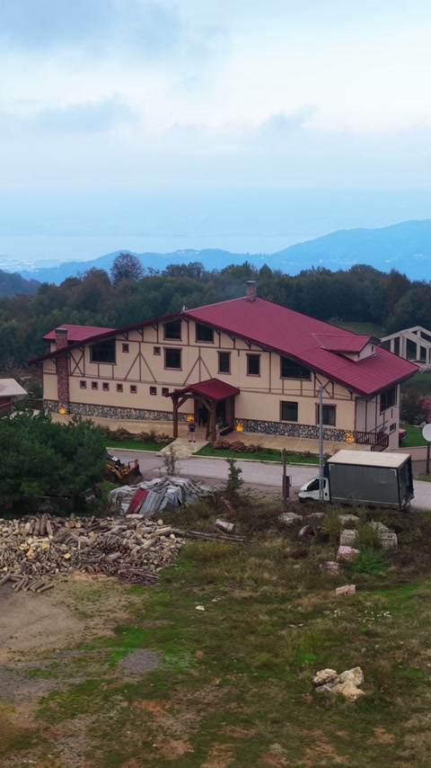 Kırmızı çatılı yapının dış cephesi çevre düzenlemesiyle uzaktan gösteriliyor