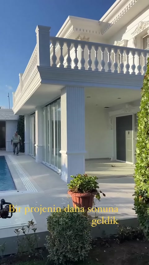 Facciata di villa completata con colonne decorative scanalate e balaustre per balconi