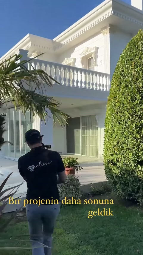Bahçeden yapılan çekimde villanın sütunlu terası ve korkuluklu balkonu görülüyor.