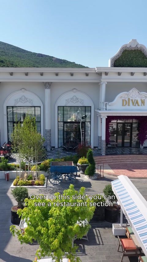 La facciata del ristorante presenta finestre ad arco, colonne e una disposizione con piscina