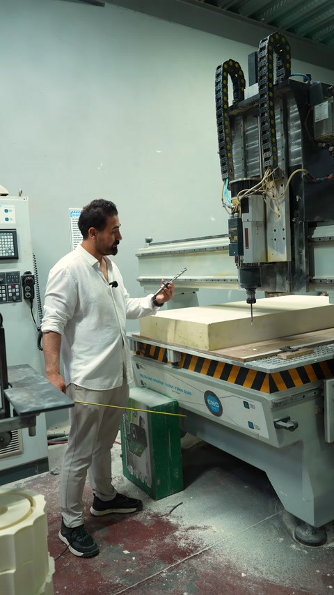 Operatör CNC tezgâhı yanında üretim hazırlığını anlatıyor