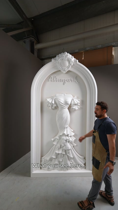L'artigiano indica la parte della gonna del rilievo dell'abito da sposa sul pannello ad arco