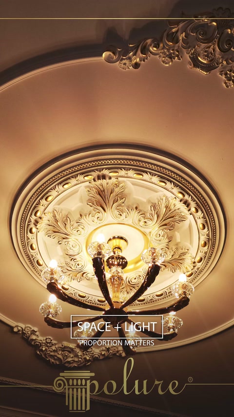 Un medaglione da soffitto rotondo incornicia un lampadario in un interno decorato.