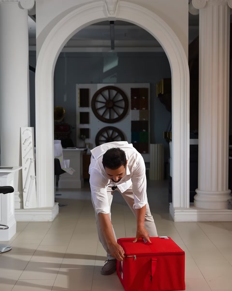 Il coperchio della scatola viene preparato chinandosi sulla borsa rossa