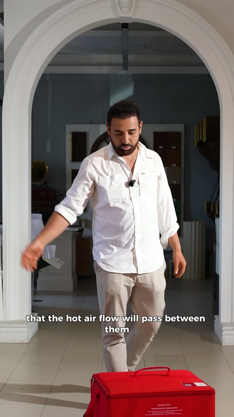 Presenter points to red case on ground with hand while explaining.