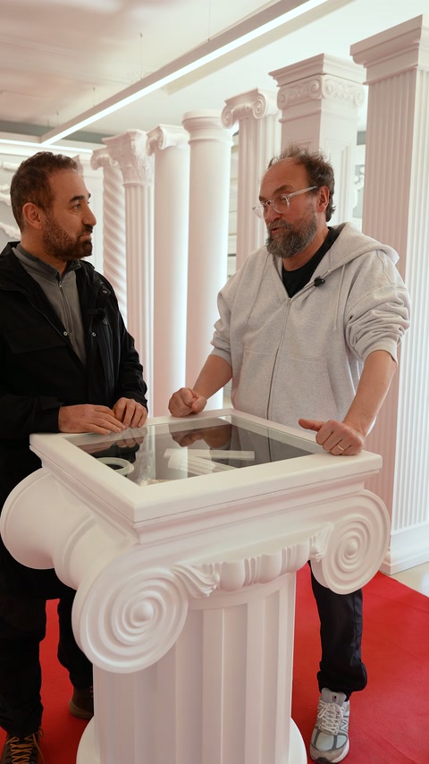 Üretici ve ziyaretçi, sütun kaidesinin yanında ürünleri değerlendiriyor