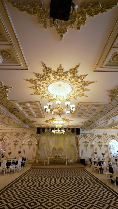 Symmetrical ballroom interior combines patterned flooring with ornate ceiling decoration