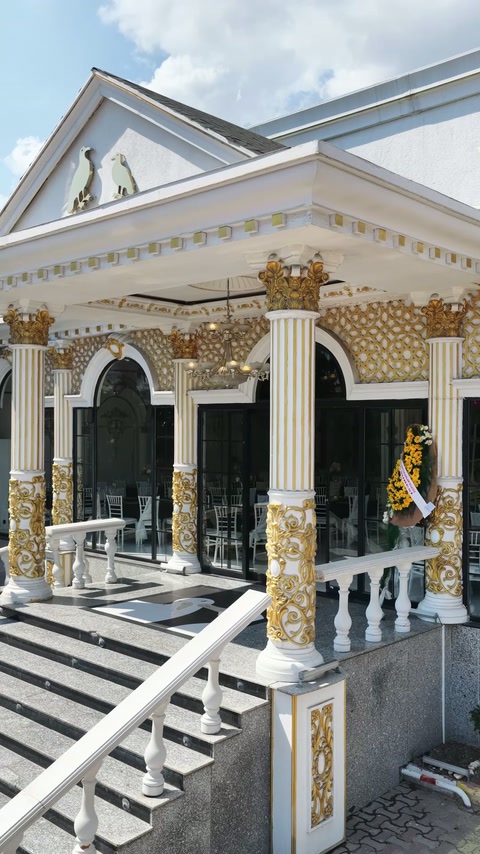 Exterior entrance features fluted columns, capitals and decorative gold reliefs