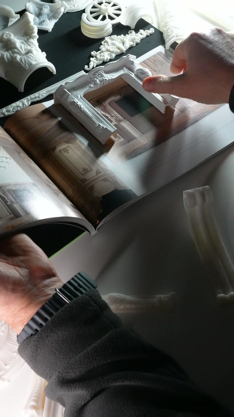 A hand points inside the miniature frame placed across the page.