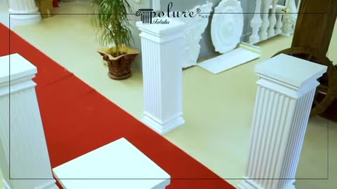 Modelli di colonne basse bianche disposti lungo un tappeto rosso