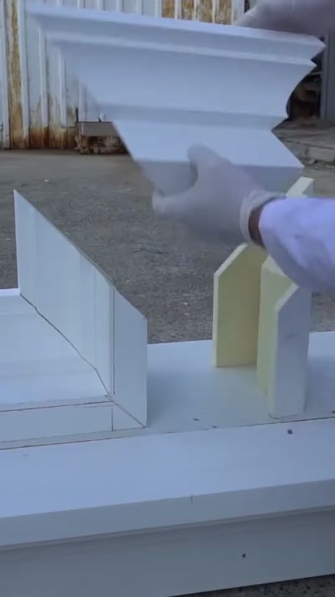 Le parti della cornice della finestra in poliuretano vengono preparate per il taglio sul banco di lavoro esterno
