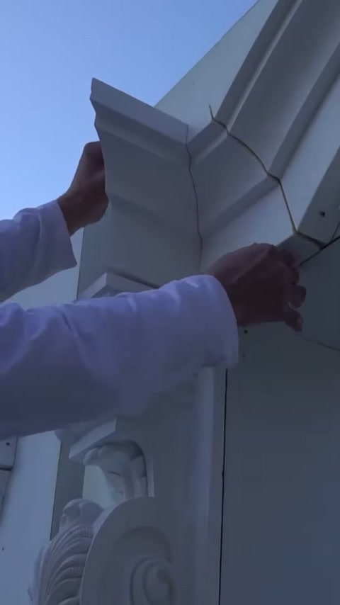 L'artigiano posiziona lo spigolo della cornice intorno alla finestra sulla facciata