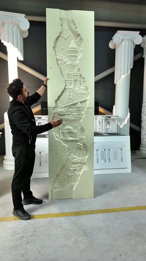 Il presentatore indica i dettagli lungo l’alto pannello murale scolpito