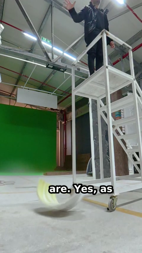 Presenter watches the dropped moulding descend beside the wheeled platform