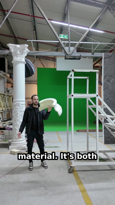 Presenter raises two curved moulding pieces beside the test platform