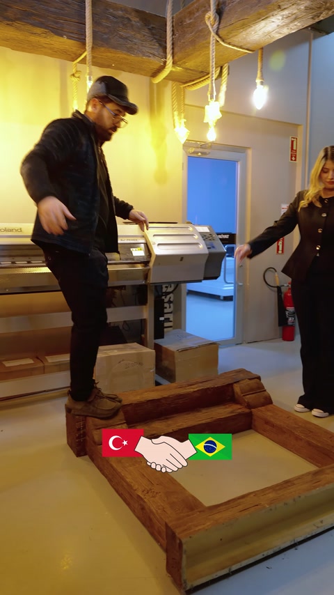 Elementi decorativi effetto legno vengono mostrati durante la lavorazione su una macchina.