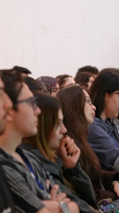 Salondaki öğrenciler mimarlık etkinliğini oturdukları yerden dikkatle dinliyor