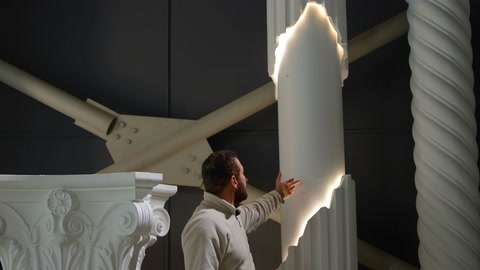 Una colonna illuminata che si sviluppa verso l'alto e un fusto tortile sono mostrati insieme.