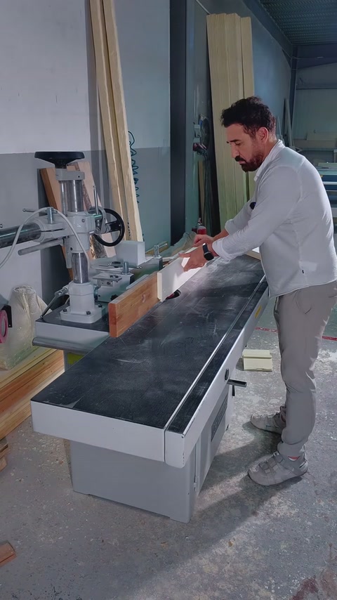 Usta uzun beyaz profili makine tablasında ilerleterek işlem uyguluyor.