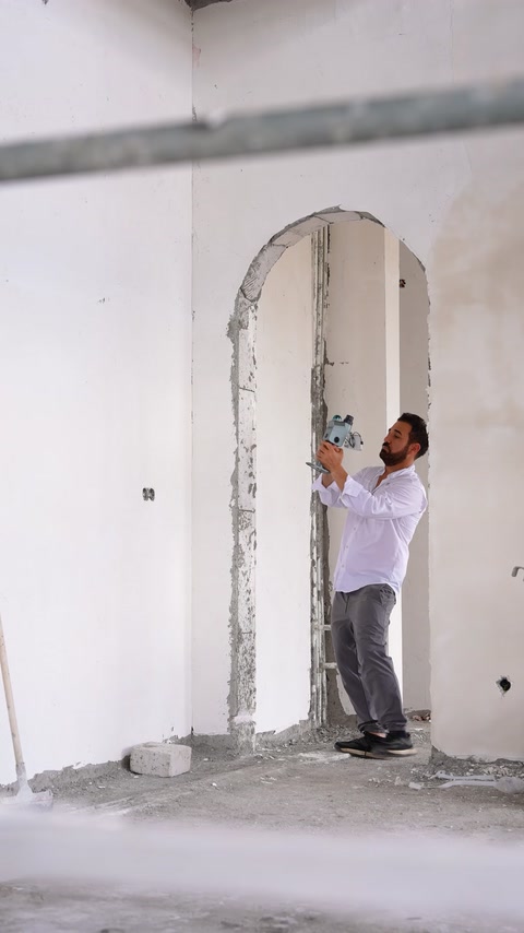 Un artigiano applica un rivestimento decorativo su un passaggio ad arco nella parete