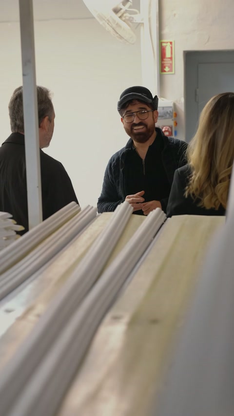 Team members evaluate long decorative profile samples together in the workshop